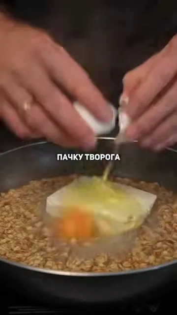 Шаг 2: Добавить пачку творога и пару яиц в сковороду с геркулесом